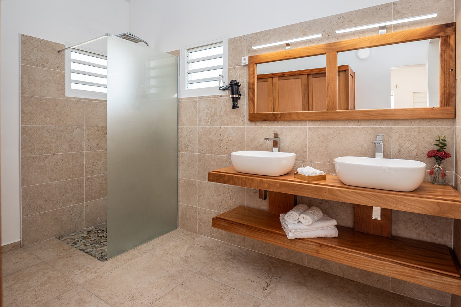 Salle de bain avec carrelage en terre et lavabo en duo haut de gamme et sèche cheveux mural