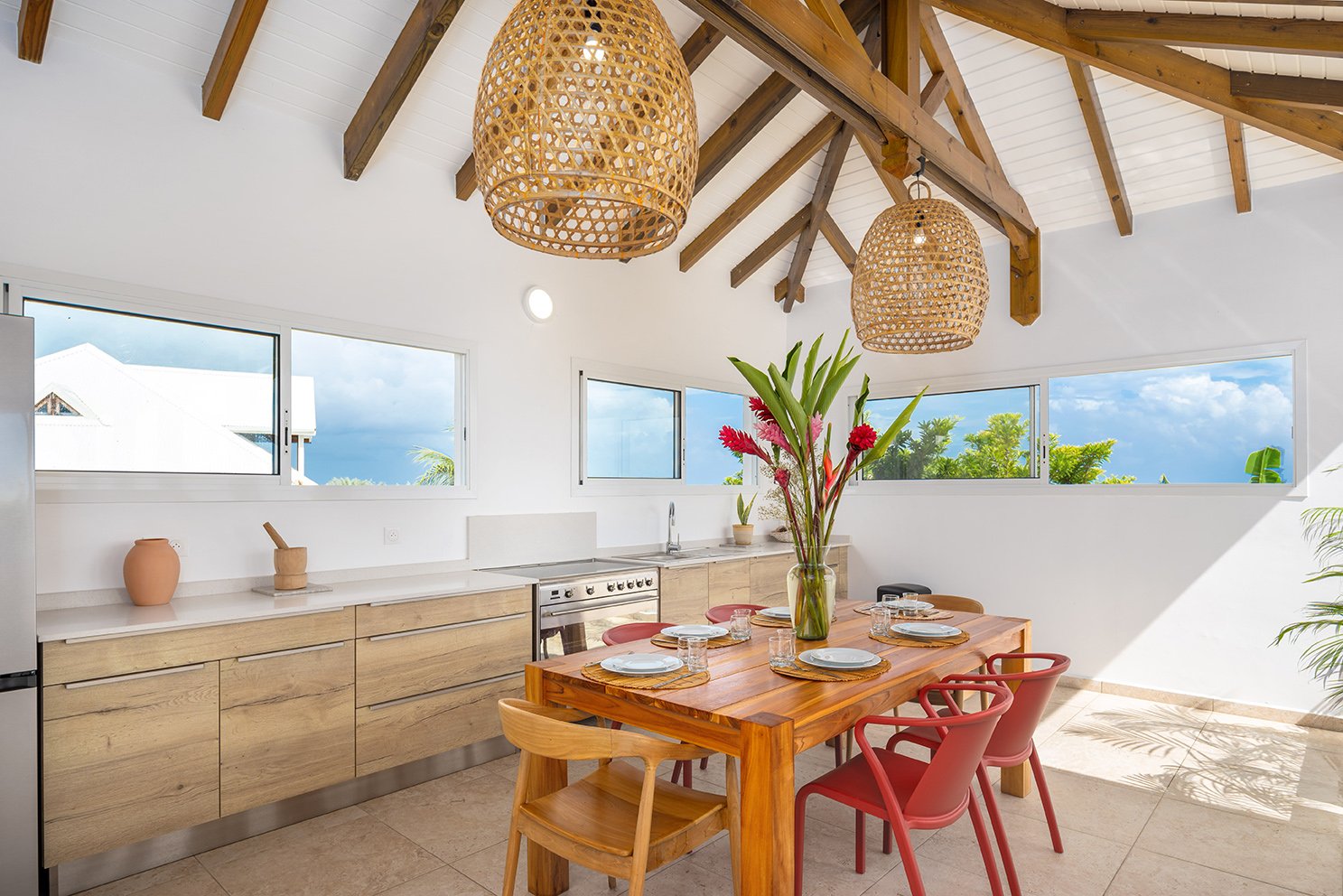 Cuisine toute équipée extérieur avec table en bois pour 6 personnes et vue sur mer