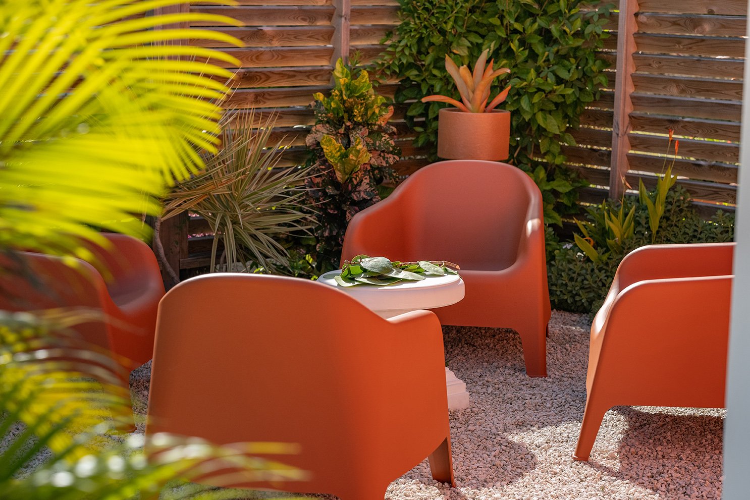 Image d'un coin detente avec Fauteuil table basse et pot de fleurs dans un jardin